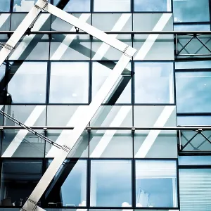Modern glass building with geometric metal framework and reflections