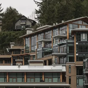 Modern hillside houses with large glass windows amid a wooded area in Horseshoe Bay