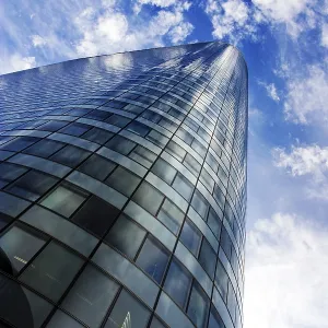 Modern skyscraper under cloudy blue sky