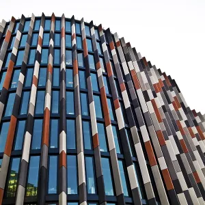 Modern skyscraper with a colorful facade of glass panels and abstract design