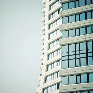 Modern skyscraper with a curved design and blue glass windows against a clear sky