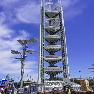 Modern tower under blue sky with light clouds and urban environment Modern tower under blue sky with light clouds and urban environment