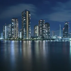 Modern Tsukuda district of Tokyo at night over waters of Sumida River