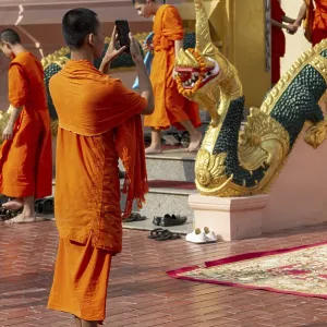 Monk in front of a Buddha statue