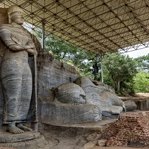 Monumental rock statue with standing and resting figure under a canopy surrounded by nature and brick walls Monumental rock statue with standing and resting figure under a canopy surrounded by nature and brick walls