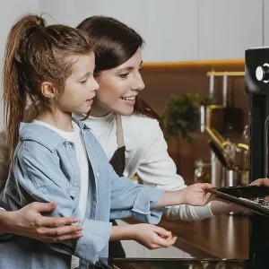Mother daughter baking cookies home together