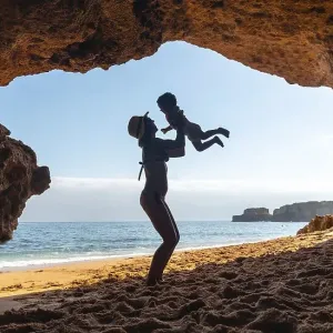 Mother with son in the cave on the beach in the Algarve Mother with son in the cave on the beach in the Algarve