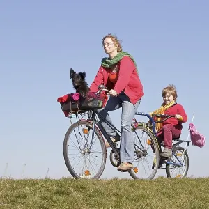 Mother, son and a dog on a bicycle tour