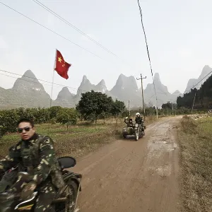 Motorcyclist in front of karst mountains in Yangshuo Motorcyclist in front of karst mountains in Yangshuo