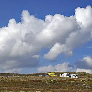 Motorhomes on a hilly landscape under large Motorhomes on a hilly landscape under large