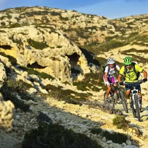 Two mountain bikers cycle in rocky terrain