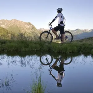 Mountainbiker on the shore of a mountain lake