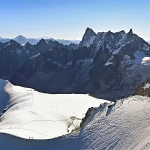 Mountaineers climb over a snow-covered mountain ridge