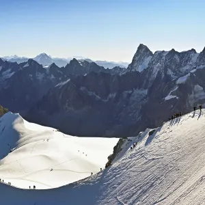 Mountaineers climb over a snow-covered mountain ridge