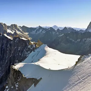 Mountaineers climb over a snow-covered ridge