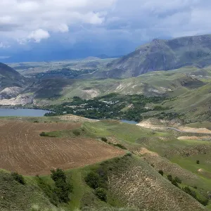 Mountains and valleys with agricultural fields under cloudy sky