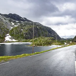 Narrow and dangerous mountain road glitters from the rain