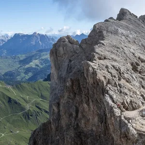 Narrow mountain path on the steep rock face of the Marmolada with shelters from WW1