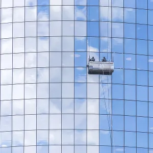 NEW YORK, USA - 16 MAY, 2019: Two cleaners washing the windows of modern skyscraper in New York NEW YORK, USA - 16 MAY, 2019: Two cleaners washing the windows of modern skyscraper in New York