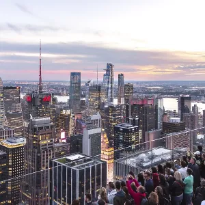 NEW YORK, USA - 17 MAY, 2019: Tourists taking pictures from a rooftop on Manhattan skyscraper rockefeller center NEW YORK, USA - 17 MAY, 2019: Tourists taking pictures from a rooftop on Manhattan skyscraper rockefeller center
