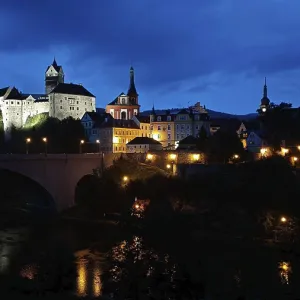 Night view of an illuminated castle and city on a river