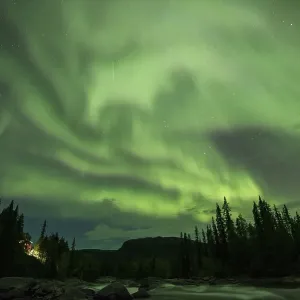 Northern Lights or Aurora Borealis over the river Gamajahka or Kamajakka