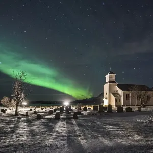 Northern lights over cemetery and church of Gimsoy