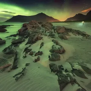 Northern lights over rocky beach