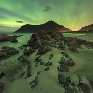 Northern lights over rocky beach