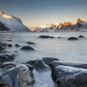 Norwegian fjord, snow-covered mountains at sunset Norwegian fjord, snow-covered mountains at sunset