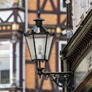 Nostalgic lantern in front of a half-timbered house with distinctive architectural patterns and windows Nostalgic lantern in front of a half-timbered house with distinctive architectural patterns and windows