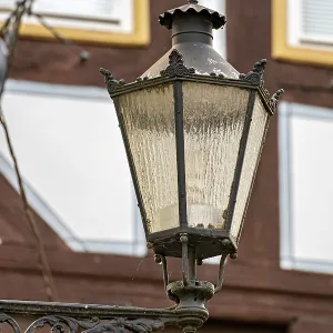 Nostalgic lantern in front of a half-timbered house with windows in a traditional cityscape Nostalgic lantern in front of a half-timbered house with windows in a traditional cityscape