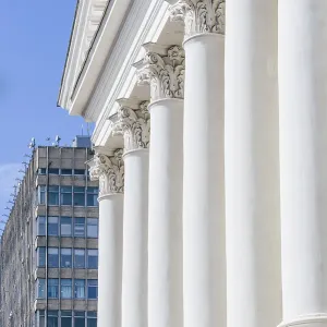 Front of Old Buildig with Columns and Skyscrapper on Background Front of Old Buildig with Columns and Skyscrapper on Background