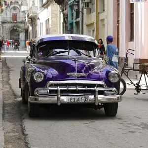 Old classic car parked in a busy street with colonial architecture Old classic car parked in a busy street with colonial architecture