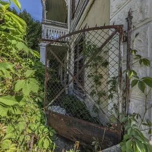 Old garden gate of a multi-storey residential building built in 1903 in front of demolition
