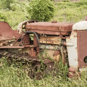 Old neglected rusty small vintage caterpillar tractor on green meadow Old neglected rusty small vintage caterpillar tractor on green meadow