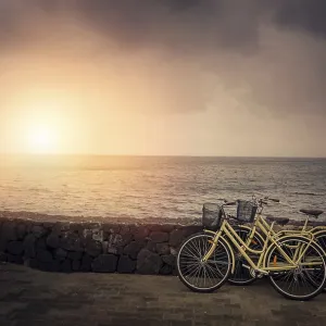 Two old retro vintage bicycles rested on a stone wall on the seaside in Lanzarote