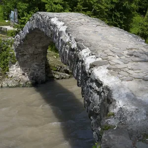 Old stone bridge spanning a river in green surroundings