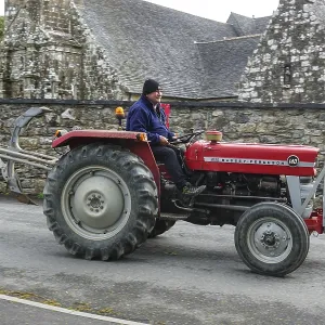Old tractor Massey Ferguson 140 in front of church and chapel Sainte Nonne Old tractor Massey Ferguson 140 in front of church and chapel Sainte Nonne