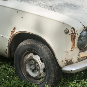 Old weathered abandoned neglected rusty broken vintage obsolete car closeup Old weathered abandoned neglected rusty broken vintage obsolete car closeup