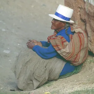 Old woman sitting on the side of the road