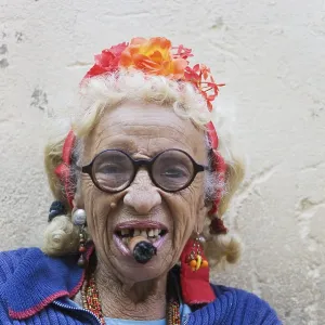 Old woman wearing coulorful clothes posing with a cigar