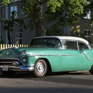 Oldsmobile 88 built in 1954, in front of Swedish wooden house
