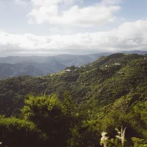 Panoramic shot of green mountains with deep valleys on a cloudy day under a blue sky Panoramic shot of green mountains with deep valleys on a cloudy day under a blue sky