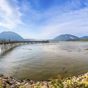 Panoramic view of a long wooden pier stretching into the tranquil waters of shuswap lake Panoramic view of a long wooden pier stretching into the tranquil waters of shuswap lake