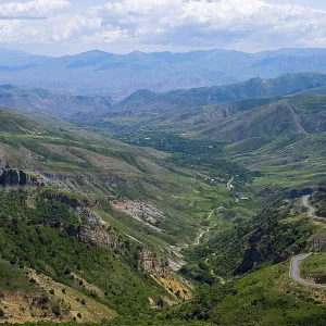 Panoramic view of mountains, green landscape with winding roads Panoramic view of mountains, green landscape with winding roads
