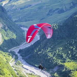 A paraglider floats over a narrow A paraglider floats over a narrow