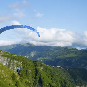 Paraglider flying with blue sky and mountain scenery Paraglider flying with blue sky and mountain scenery