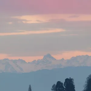 Pastel-colored sky over a lake and mountains in the distance Pastel-colored sky over a lake and mountains in the distance