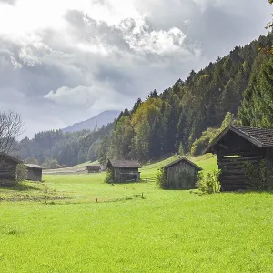 Pasture with haybars and mountains with dark clouds in the Stubai Valley between Telfes and Mieders